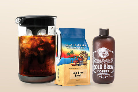 A glass pitcher of cold brew with ice beside a Cold Brew Blend bag and a bottled cold brew.