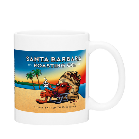 White C-handle mug with a full color beach scene: a cartoon character in a beach chair holding coffee, palm trees and "Coffee Tanned to Perfection"