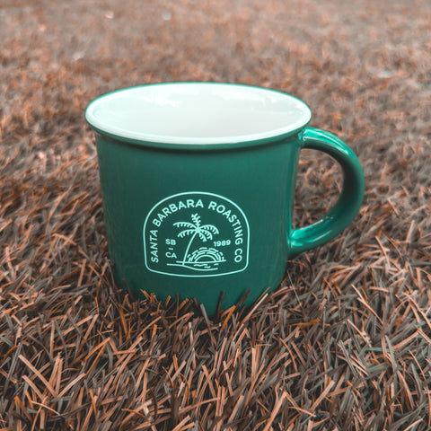 Green Kindle mug sitting outdoors on pine needles