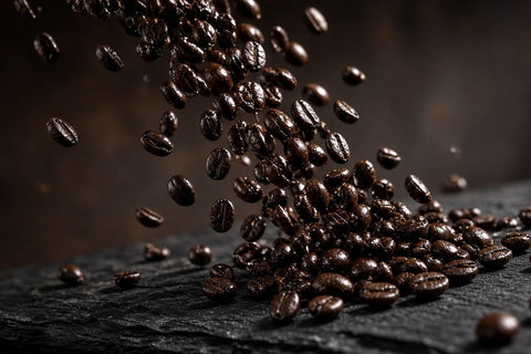 Dark roast coffee beans pouring onto slate. RoCo dark roast.