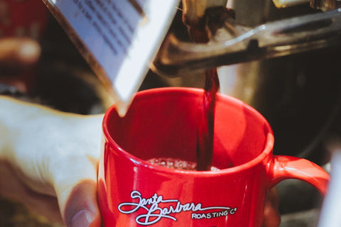 Dark drip coffee pouring into a red RoCo mug.